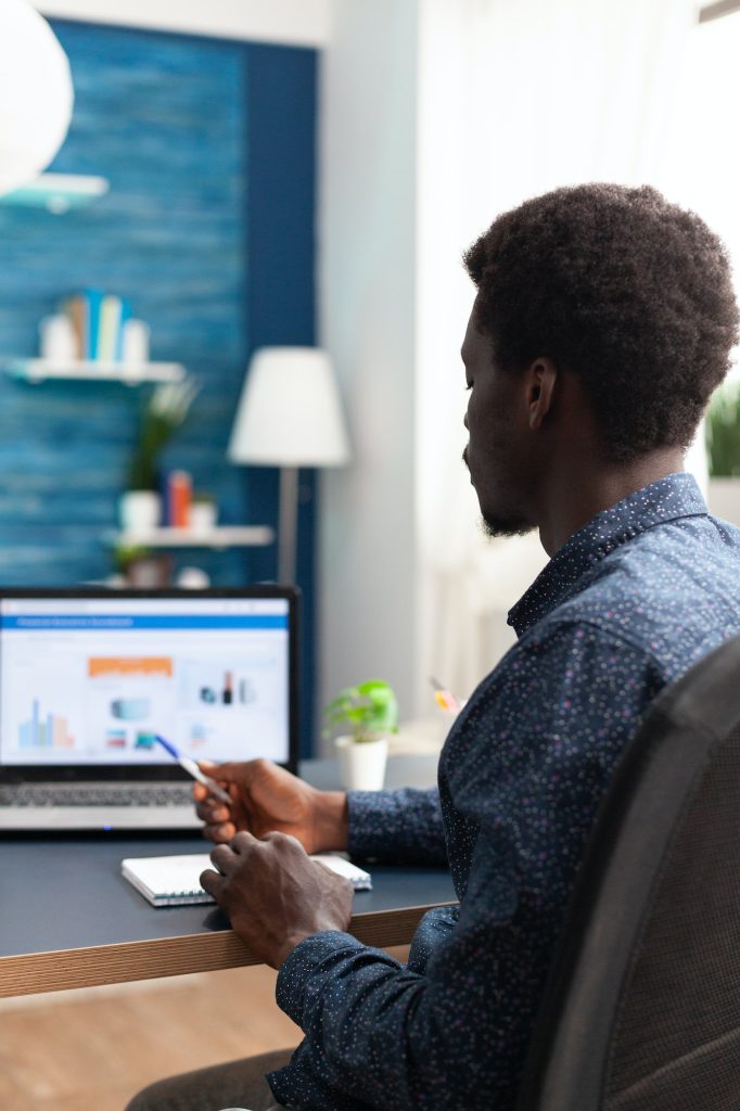 Black man working from home using financial economy data app